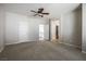 Carpeted bedroom featuring a ceiling fan, neutral colored walls, and multiple white doors at 11900 Calle De Sol Dr, Las Vegas, NV 89138