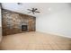 Living room features a stone accent wall with a fireplace, neutral paint, and tile floors at 11900 Calle De Sol Dr, Las Vegas, NV 89138