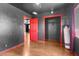 View of bedroom with dark walls, wooden floors, red trim and doors and a view into an adjacent room at 121 N 20Th St, Las Vegas, NV 89101