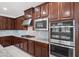 Modern kitchen with stainless steel appliances, granite countertops and dark wood cabinets at 12219 Crystal Shore Ave, Las Vegas, NV 89138