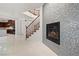 Open-concept living room with fireplace, staircase, and access to the kitchen at 12219 Crystal Shore Ave, Las Vegas, NV 89138