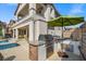 Outdoor kitchen with built-in grill, granite countertops, and bar seating, perfect for entertaining at 12219 Crystal Shore Ave, Las Vegas, NV 89138