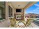 Inviting outdoor patio featuring a stone fireplace, TV, and views of the pool and waterfall at 12219 Crystal Shore Ave, Las Vegas, NV 89138