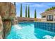Inviting pool featuring a rock waterfall detail and cool blue tiling, perfect for relaxation at 12219 Crystal Shore Ave, Las Vegas, NV 89138