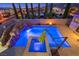 A luxury pool and spa area with a rock waterfall, fire pit, and ambient lighting at 12219 Crystal Shore Ave, Las Vegas, NV 89138