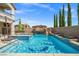 Beautiful pool with a spa, a rock waterfall and water slide, and a vibrant blue tile design at 12219 Crystal Shore Ave, Las Vegas, NV 89138
