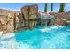 Beautiful pool area featuring a rock waterfall and lush landscaping at 12219 Crystal Shore Ave, Las Vegas, NV 89138