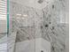 A luxurious walk-in shower featuring marble tile and modern fixtures at 12219 Crystal Shore Ave, Las Vegas, NV 89138