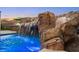 Captivating rock waterfall cascading into the pool, creating a tranquil backyard oasis at 12219 Crystal Shore Ave, Las Vegas, NV 89138