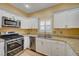 Modern kitchen showcasing stainless steel appliances, granite countertops, and white cabinets at 1435 Orange Jubilee Rd, Henderson, NV 89014