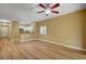 Spacious living area with wood-look flooring, a ceiling fan, and a view into the kitchen at 1435 Orange Jubilee Rd, Henderson, NV 89014