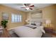 A cozy main bedroom featuring a ceiling fan, window with shutters, and neutral decor for relaxation at 1435 Orange Jubilee Rd, Henderson, NV 89014