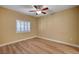 A vacant main bedroom featuring a ceiling fan, window with shutters, and hardwood flooring at 1435 Orange Jubilee Rd, Henderson, NV 89014