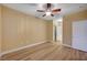 A vacant main bedroom featuring a ceiling fan, ensuite bathroom, and hardwood flooring at 1435 Orange Jubilee Rd, Henderson, NV 89014