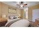 A stylish main bedroom featuring a ceiling fan, ensuite bathroom, and neutral decor for relaxation at 1435 Orange Jubilee Rd, Henderson, NV 89014
