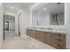 Stylish bathroom with an expansive lighted mirror, double vanity, and access to bedroom and shower at 19 Rue Grimaldi Way, Henderson, NV 89011