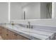 Close-up of bathroom vanity with marble countertop and double sink with modern bronze faucets at 19 Rue Grimaldi Way, Henderson, NV 89011