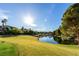 Scenic view of a golf course with a pond, green grass, and mature trees at 19 Rue Grimaldi Way, Henderson, NV 89011