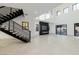 Open-concept living room featuring a modern staircase, high ceilings, and a sleek fireplace at 19 Rue Grimaldi Way, Henderson, NV 89011