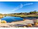 Beautiful pond reflecting luxury homes on a golf course with a bunker in the foreground at 19 Rue Grimaldi Way, Henderson, NV 89011