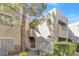 Two-story condo showcasing landscaped grounds, and stairs leading up to private balconies on a sunny day at 1900 Mountain Hills Ct # 203, Las Vegas, NV 89128