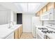 Bright kitchen features white appliances, tile countertops and flooring, and natural light at 1900 Mountain Hills Ct # 203, Las Vegas, NV 89128