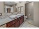 A modern bathroom with a double sink vanity, tiled floors and decorative mirrors at 222 Hollyfern St, Henderson, NV 89074