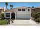 Two-story home featuring desert landscaping, a tile roof, an arched entry gate, and a two-car garage at 222 Hollyfern St, Henderson, NV 89074