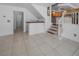Open-concept living room with tile flooring, a staircase, and wet bar access at 222 Hollyfern St, Henderson, NV 89074