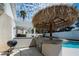 Inviting outdoor kitchen with built-in grill, palapa, and bar area, perfect for entertaining by the pool at 222 Hollyfern St, Henderson, NV 89074