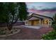A cozy backyard featuring a covered patio, landscaped with small plants and a mature tree at 2579 Ivoryhill St, Las Vegas, NV 89135