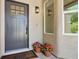 Inviting front door with decorative window, enhanced by potted flowers and a stylish outdoor light fixture at 2579 Ivoryhill St, Las Vegas, NV 89135