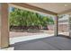Covered patio providing view of the spacious backyard with mature trees and gravel landscaping at 2579 Ivoryhill St, Las Vegas, NV 89135