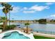 Picturesque backyard view of a lake with a boat dock, surrounded by lush tropical trees and an inviting pool at 2589 Sun Reef Rd, Las Vegas, NV 89128