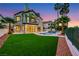 A backyard with an inground pool, palm trees, outdoor living space, and artificial lawn at 2589 Sun Reef Rd, Las Vegas, NV 89128