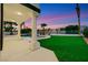 A covered outdoor patio with columns that overlooks the artificial grass lawn and pool at 2589 Sun Reef Rd, Las Vegas, NV 89128