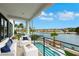 This covered balcony features comfy seating, a refreshing pool view, and tranquil waterfront scenery at 2589 Sun Reef Rd, Las Vegas, NV 89128