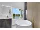 Bright bathroom with freestanding tub overlooking water view, featuring luxury fixtures and a spacious layout at 2589 Sun Reef Rd, Las Vegas, NV 89128