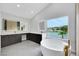 Bright bathroom boasts soaking tub, lake views, double vanity and illuminated mirrors at 2589 Sun Reef Rd, Las Vegas, NV 89128