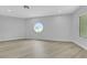 Bright, empty bedroom with stylish wood-look flooring and unique round window, creating a serene atmosphere at 2589 Sun Reef Rd, Las Vegas, NV 89128