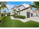 Beautiful two-story home with a two-car garage, lush green lawn, and mature landscaping at 2589 Sun Reef Rd, Las Vegas, NV 89128