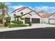 Beautiful home with a two-car garage, complemented by a well-manicured lawn and verdant tropical plants at 2589 Sun Reef Rd, Las Vegas, NV 89128