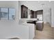 Modern kitchen featuring dark wood cabinets, stainless steel appliances, and a white countertop island at 2589 Sun Reef Rd, Las Vegas, NV 89128
