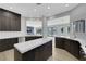 Modern kitchen featuring dark wood cabinets, stainless steel appliances, and a white countertop island at 2589 Sun Reef Rd, Las Vegas, NV 89128