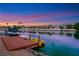 A picturesque waterfront setting features a dock, boat, and paddle boats, ideal for lakeside living at 2589 Sun Reef Rd, Las Vegas, NV 89128
