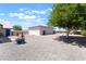 Spacious backyard includes gravel cover, decorative metal fire pit, and desert landscaping for easy upkeep at 2650 Sagebrush Ave, Pahrump, NV 89048