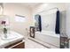 Bright bathroom with a double sink vanity, custom tiled accents, and a separate tub and toilet space offering privacy at 2650 Sagebrush Ave, Pahrump, NV 89048