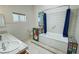 Bathroom featuring a tub with colorful tiled accents, dual sinks, and neutral tiling at 2650 Sagebrush Ave, Pahrump, NV 89048