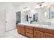 Well-lit bathroom features a double sink vanity, decorative tiles, and a shower tub combo, blending functionality with style at 2650 Sagebrush Ave, Pahrump, NV 89048