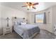 Comfortable bedroom featuring a decorative ceiling fan, bedside tables with lamps, and a large window with desert view at 2650 Sagebrush Ave, Pahrump, NV 89048